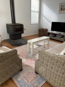 a living room with two couches and a wood stove at Griffith St Beach House in Port Fairy