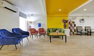 uma sala de estar com cadeiras, um sofá e uma mesa em Treebo Trend Ahinsa Residency Sohna Road em Gurgaon