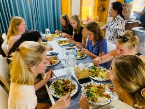 a group of women sitting around a table eating food at Munus Travel Home in Kathmandu