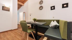 a dining room with a green couch and a table at Apart Al-Aviöler in Ischgl