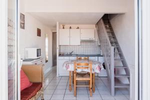 a kitchen with a table and chairs and a staircase at Appart.3_ T3 - 4 pers - 150 m/mer tout confort in Sainte-Marie-la-Mer