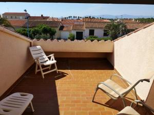 two chairs sitting on a brick patio on a balcony at Appart.3_ T3 - 4 pers - 150 m/mer tout confort in Sainte-Marie-la-Mer