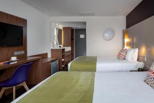 a hotel room with two beds and a desk at Campanile Xi'an Bell Tower Huimin Street in Xi'an