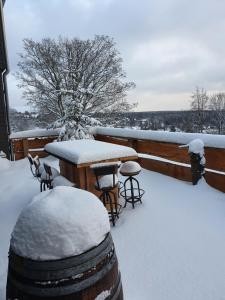 un patio con mesa y sillas en la nieve en WLodgeOne en Braunlage