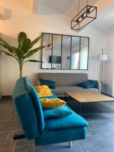 a living room with a blue couch and a table at Edith et Jean-Paul in Porto-Vecchio