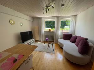 a living room with a white couch and a table at 2-Zimmer-Nichtraucher-Ferienwohnung Strobel in Tübingen