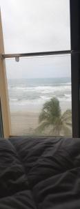a view of a beach from a bedroom window at Lovely Beach Apartment in Salalah