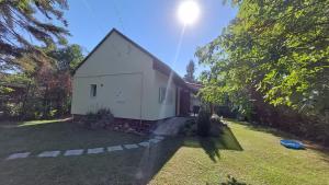 a small white house in the middle of a yard at Rév1 Vendégház in Révfülöp