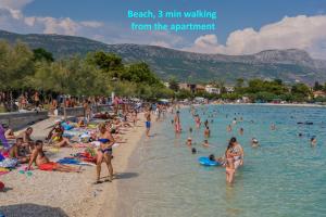 a group of people swimming in the water at a beach at Seafront apartments Karlo in Kaštela