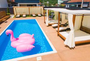 a swimming pool with two pink flamingos in the water at Drina Resort in Bajina Bašta