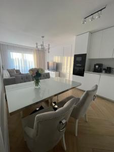 a kitchen and living room with a table and chairs at Luksusowy Apartament na Wydmach Międzywodzie in Międzywodzie