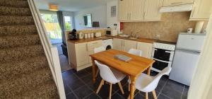 uma cozinha com uma mesa de madeira e electrodomésticos brancos em 3 Manor Villas Newquay em Newquay
