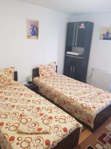 a bedroom with two beds and a refrigerator at Casa Stela in Iaşi