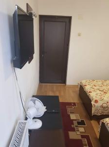 a room with a fan and a bed and a door at Casa Stela in Iaşi
