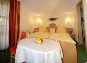 una habitación de hotel con 2 camas y una mesa con un bol de fruta en Frühstückspension Sunnhäusl, en Sankt Veit im Pongau