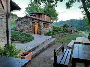 a stone building with two benches and a table at Agriturismo Cà Nova in Palazzuolo sul Senio