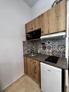 a kitchen with wooden cabinets and a sink at Central Double Room Ground floor in Heraklio Town