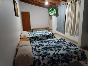 1 dormitorio con 2 camas con sábanas azules y blancas en El Arrayan, en Valle de Bravo