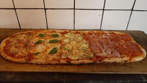 a pizza with ham and cheese on a cutting board at Agriturismo Cà Nova in Palazzuolo sul Senio +10 photos