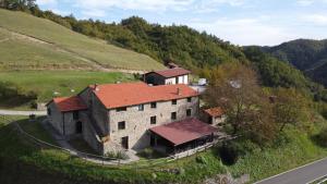 a large building with a red roof on a hill at Agriturismo Cà Nova in Palazzuolo sul Senio