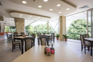 a restaurant with tables and chairs and a large window at Hotel Coop - Kiten in Kiten