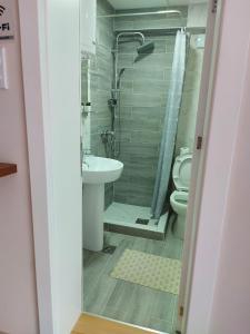 a bathroom with a shower and a sink and a toilet at Apartmani MALINA in Vrnjačka Banja
