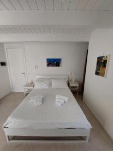 Un dormitorio blanco con una cama blanca con toallas. en MandorleOlio en Polignano a Mare