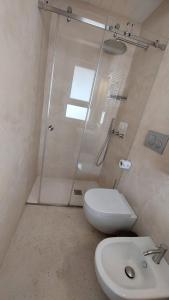 een badkamer met een douche, een toilet en een wastafel bij MandorleOlio in Polignano a Mare