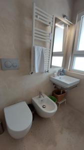a white bathroom with a toilet and a sink at MandorleOlio in Polignano a Mare