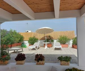 a patio with a table and chairs and an umbrella at MandorleOlio in Polignano a Mare