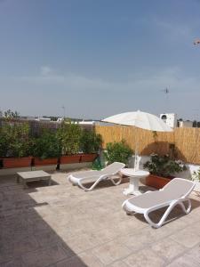 a patio with a table and chairs and an umbrella at MandorleOlio in Polignano a Mare