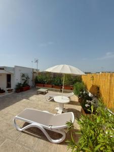 a patio with a table and an umbrella at MandorleOlio in Polignano a Mare