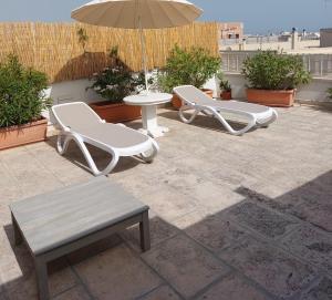 a patio with two chairs and a table and an umbrella at MandorleOlio in Polignano a Mare