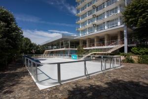 a tennis court in front of a building at Hotel Coop - Kiten in Kiten
