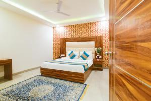a bedroom with a bed and a wooden door at Hotel Olivia Inn At Delhi Airport in New Delhi