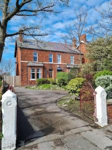 a brick house with a gate and a driveway at The Hot Tub Townhouse by Holiday Heim in Lytham St Annes