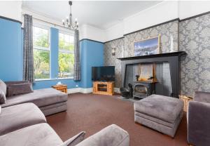 a living room with a couch and a fireplace at The Hot Tub Townhouse by Holiday Heim in Lytham St Annes