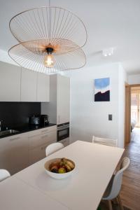 una cocina blanca con un bol de fruta en una mesa en Polaris appartement 2, en Zinal