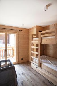 1 dormitorio con paredes de madera y 1 litera en Polaris appartement 2, en Zinal