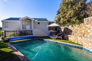 a swimming pool in front of a house at Zonnendal Family Home in charming Kalk Bay in Cape Town