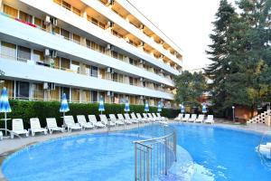 a hotel with a swimming pool with chairs and umbrellas at Hotel Oasis in Albena