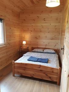 um quarto com uma cama num chalé de madeira em Gościniec Mazurek em Giżycko