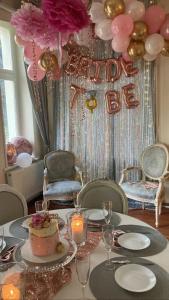a table with a birthday banner and a table with a cake at Suites La Bella in Sopot