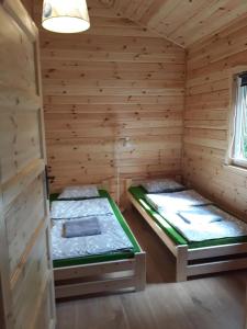 um quarto com duas camas num chalé de madeira em Gościniec Mazurek em Giżycko