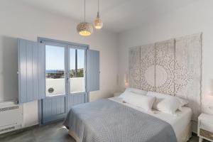 a bedroom with a bed and a large window at SantoRossa Luxury Villas in Emporio Santorini