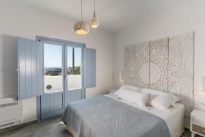 a bedroom with a bed and a large window at SantoRossa Luxury Villas in Emporio