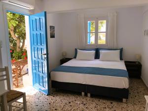 a bedroom with a bed with blue and white pillows at Meltemi Studios and Apartments in Logaras