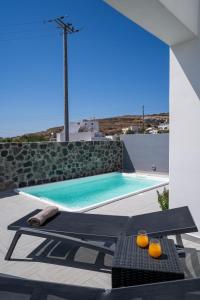 a pool with a table and oranges on a patio at SantoRossa Luxury Villas in Emporio Santorini