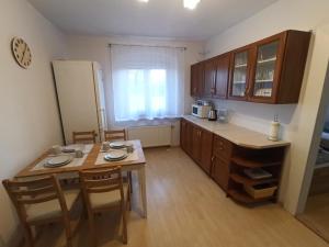 eine kleine Küche mit einem Tisch und einem Kühlschrank in der Unterkunft Apartament Sówka in Świdnica