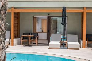 a pool with chairs and a table and an umbrella at Stella Palace Aqua Park Resort in Hersonissos